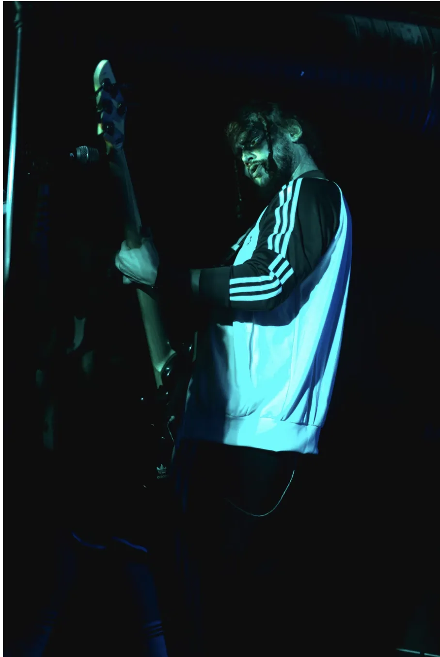 Bassist på scenen i blått konsertlys